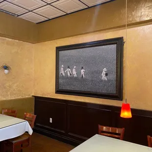 a dining room with a painting on the wall