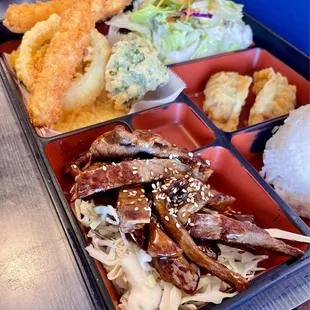 Beef Teriyaki Bento Box with 2 Shrimp Tempura, Mixed Veggie Tempura, White Rice, 2 Gyoza with Dipping Sauce, Ginger Salad.