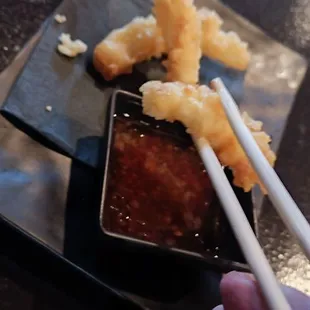 a person holding chopsticks over a plate of food