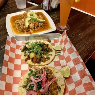 two plates of tacos and a drink