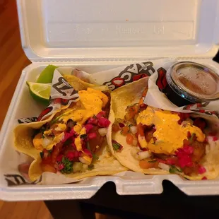 two tacos in a styrofoam container