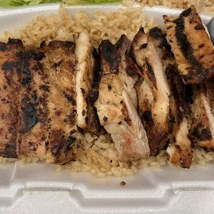 grilled chicken and rice in a styrofoam container
