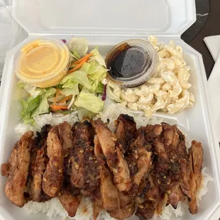 a take out container with meat and rice