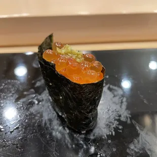 a sushi roll on a black plate