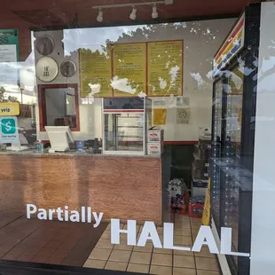 the reflection of the restaurant&apos;s sign in the window