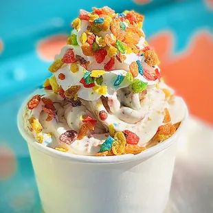 Fruity Pebbles frozen yogurt; topped with creamy whipped cream and fruity pebbles sprinkled on top.