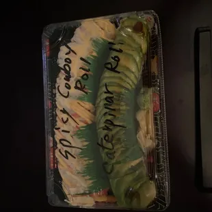 a plastic container of sushi on a table