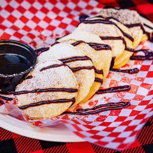 HOMEMADE BUTTERMILK PANCAKES DRIZZLED WITH GHIRARDELLI CHOCOLATE AND POWDERED SUGAR