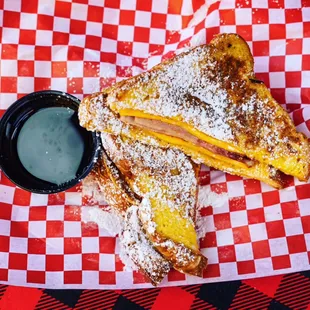 MONTE CRISTO ...TEXAS EGGBREAD FRENCH TOAST STUFFED WITH HAM EGG AND CHEESE TOPPED WITH POWDERED SUGAR AND SERVED WITH WARM MAPLE SYRUP