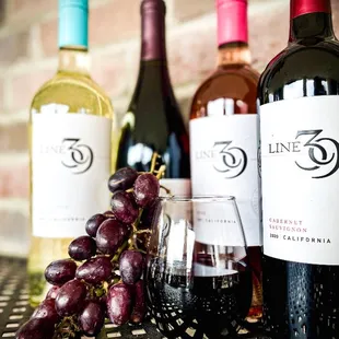 wine bottles and grapes on a table