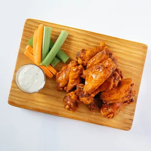 chicken wings and carrots on a cutting board