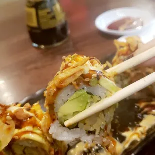 a plate of sushi with chopsticks