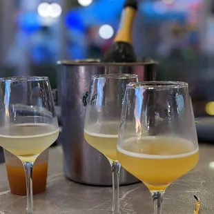 two glasses of wine and a bottle of champagne