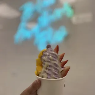 a hand holding a cup of ice cream