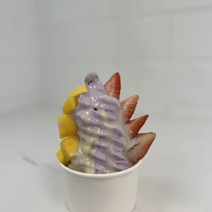a cup of ice cream with fruit on top
