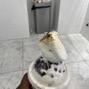 a hand holding a cup of ice cream