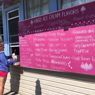 a woman standing in front of a pink sign