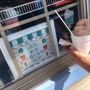 a hand holding a cup of ice cream