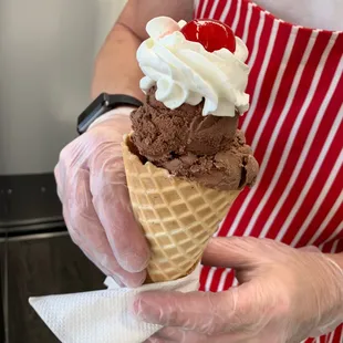a person holding an ice cream cone