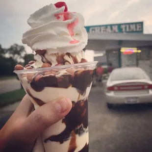 a hand holding a cup of ice cream