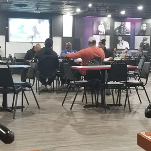 Some men just enjoying each other with a bite to eat and watching football.