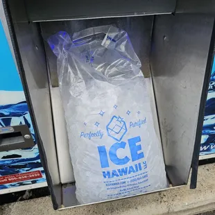The bag of ice slides out from a chute