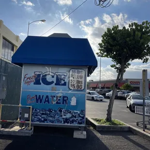 a small ice cream kiosk in a parking lot