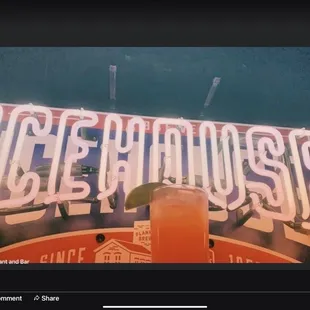 a drink in front of a neon sign