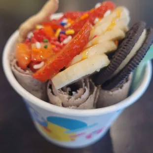 a cup of ice cream with a variety of toppings