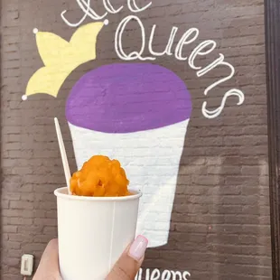 a hand holding a cup of ice cream