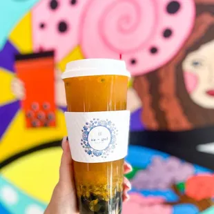 a hand holding a cup of iced tea