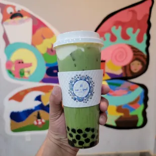 a hand holding a cup of bubble tea