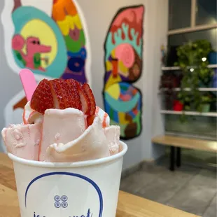 a cup of ice cream with a strawberry on top