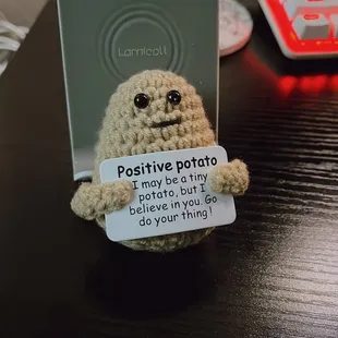 a stuffed bear with a positive potato tag