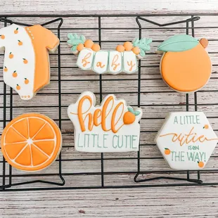 oranges and hello little cutie cookies on a cooling rack