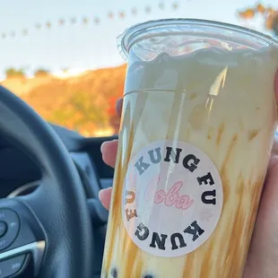 a hand holding a cup of bubble tea