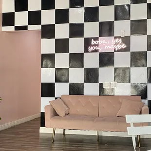 a pink couch and a black and white checkered wall