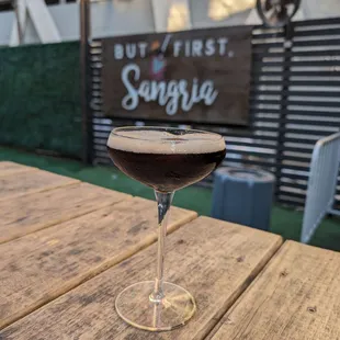 a glass of wine on a wooden table