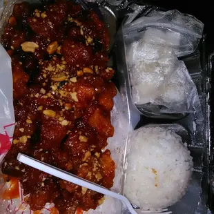 a tray of rice, meat, and sauce