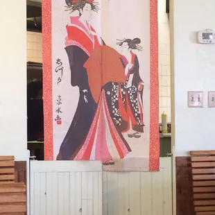 Pretty little curtain separating the kitchen from the dining area.