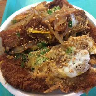 Pork Katsu Bowl with breaded, fried pork cutlets in a sweet soy sauce with eggs, onions and chives on top of a bed of rice!