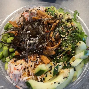 Poke bowl with my selected options (spring mix, cucumber, edamame, seaweed salad, snow crab,nori, sesame seeds, wontons, jalapeño)