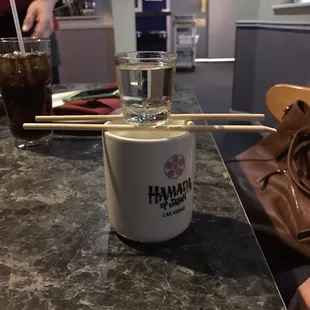 a cup of soup with chopsticks