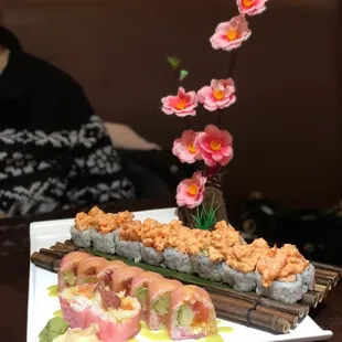 a plate of sushi and a vase of flowers