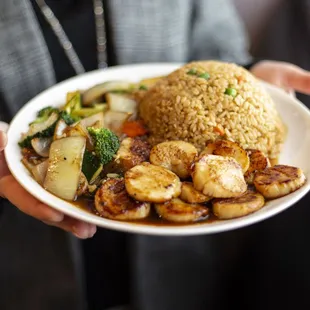 a person holding a plate of food