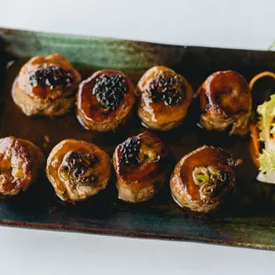 a plate of meatballs with a side salad