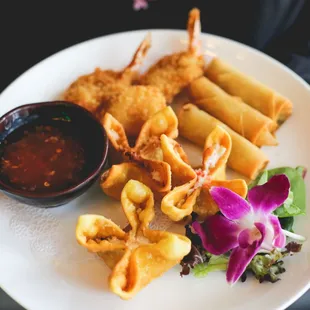 a plate of fried food with dipping sauce
