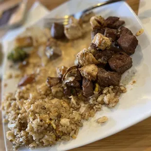 a plate of food with rice, meat and broccoli