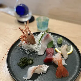 a black plate with a variety of sushi