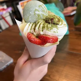 a hand holding a cone of ice cream